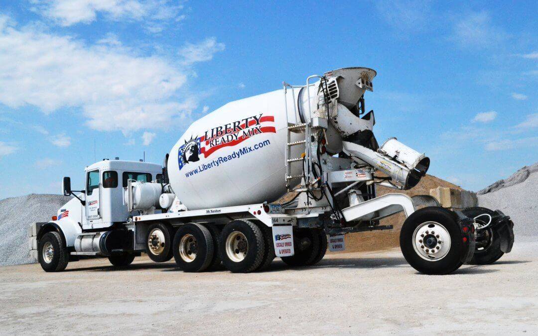 A white Liberty Ready Mix cement mixers in front of piles of recycled concrete.